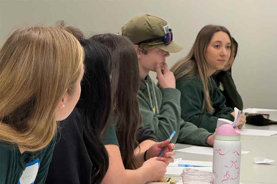 high school students at a table having a discussion