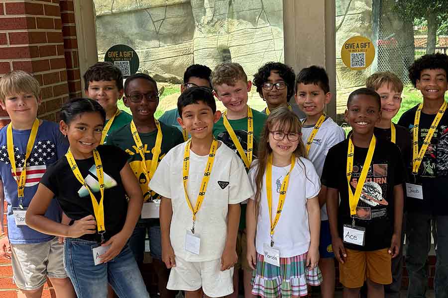 Group of young students from UYP standing in front of the bear habitat on campus