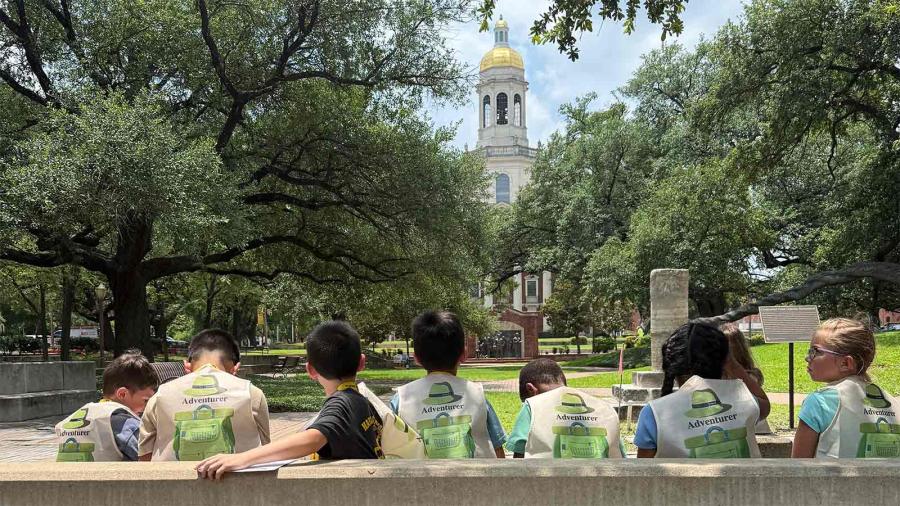 Children sitting with their backs to the camera looking towards Pat Neff